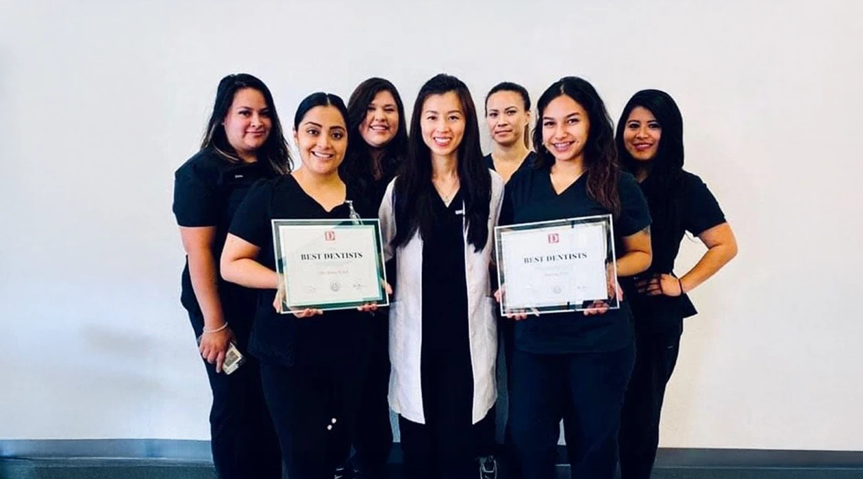 Dentist Dallas TX Nhu Dang and Team HPH Dr. Nhu Dang and the Bella Family Dental team posing and holding awards they received for being voted Best Dentists
